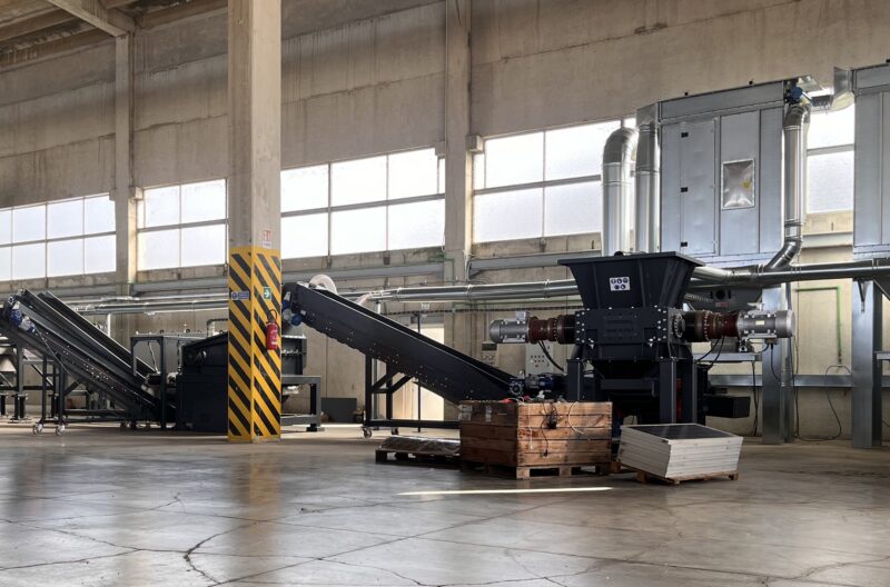 Industrial waste processing machinery in a warehouse setting.