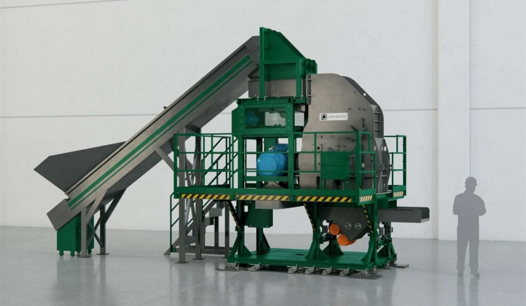 Industrial waste processing hammer mill with conveyor system in a factory setting.