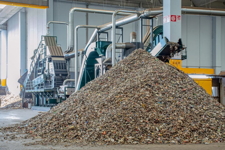 Industrial hammer mill processing waste materials at Waste Initiatives.