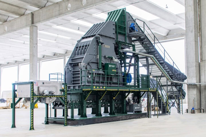 Industrial waste processing hammer mill in a factory setting.