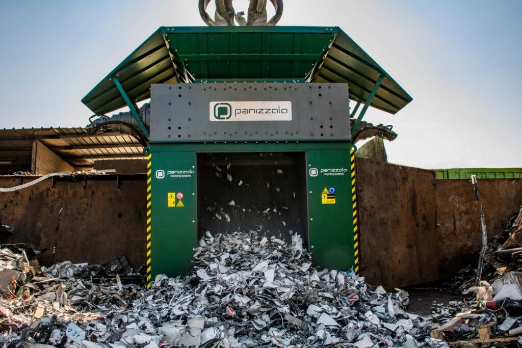 Industrial shredder processing waste materials at a recycling facility.