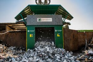 Industrial shredder processing waste materials at a recycling facility.