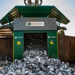 Industrial shredder processing waste materials at a recycling facility.