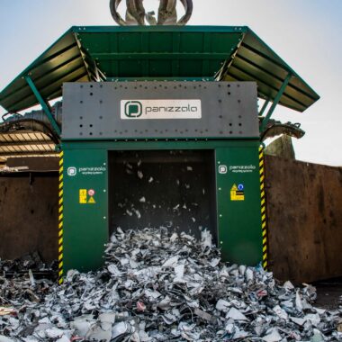 Industrial shredder processing waste materials at a recycling facility.